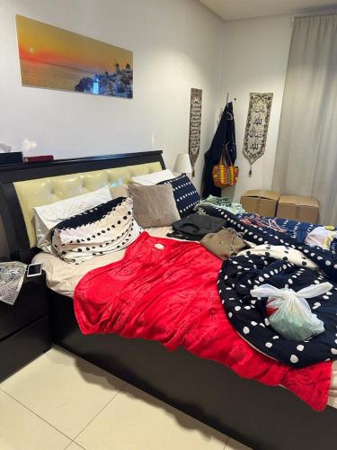 a bed with a red blanket and pillows on it at Hash&Jazz in Manama