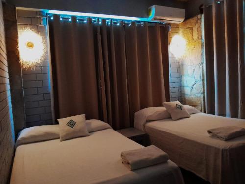 a room with two beds with lights on them at HOTEL WAYAK in Palenque