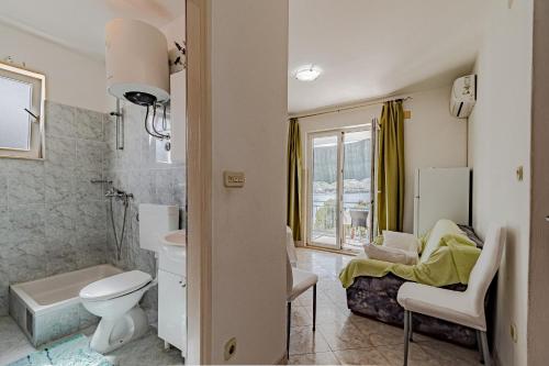 un bagno con servizi igienici e un letto in una camera. di Apartments by the sea Luka Dubrava, Peljesac - 14040 a Putniković