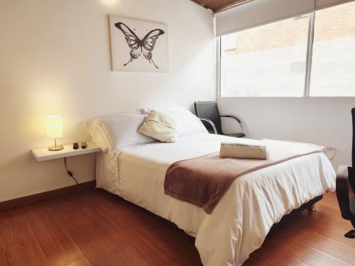 sypialnia z łóżkiem z motylem na ścianie w obiekcie HABITACION 2 Baño y balcón privado UNICENTRO w mieście Bogota
