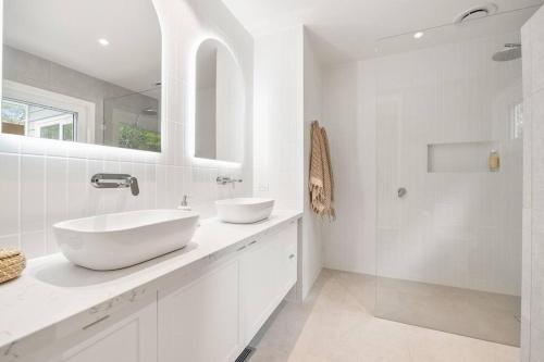 McCraeShelby Beachhouse - Scandi Hot Tub & McCrae Views的白色的浴室设有2个盥洗盆和淋浴。