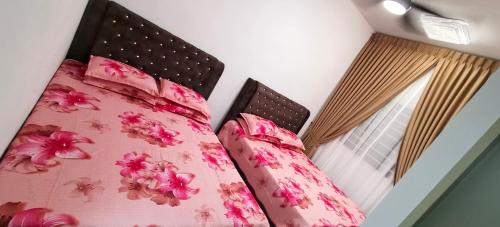 a bed with pink flowers on it with a window at Sweethome Mummy@Youthcity Nilai in Nilai