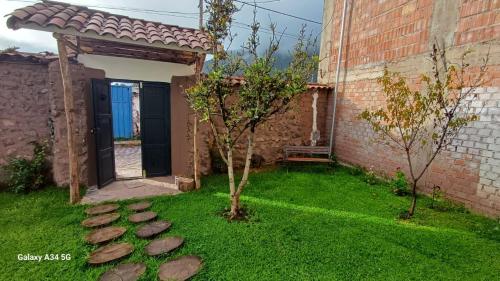 a garden with a pathway leading to a building at Andahuaylillas Quedate Aqui in Andalmailillas