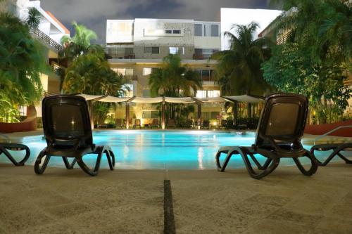 duas cadeiras sentadas em frente a uma piscina em Luxury Coral Dream em Playa del Carmen