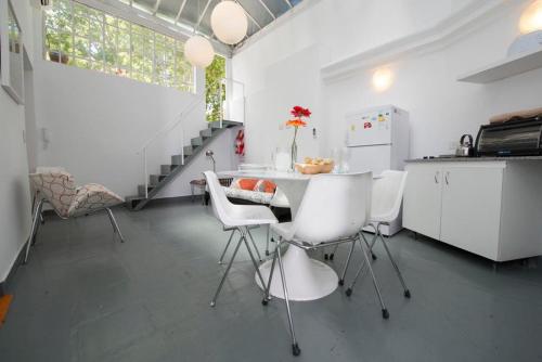 cocina con mesa y sillas blancas en una habitación en Art house apartments, en Buenos Aires