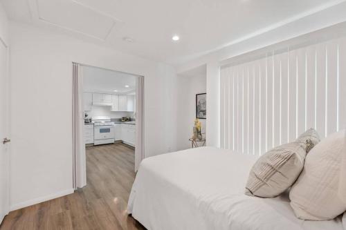 a white bedroom with a large white bed with pillows at Modern 1-Bedroom Home in a Prime LA Location in Los Angeles