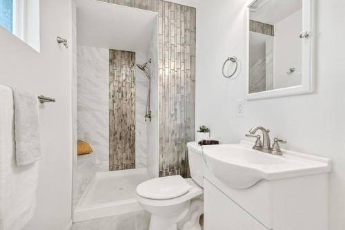 a white bathroom with a toilet and a sink at Modern 1-Bedroom Home in a Prime LA Location in Los Angeles