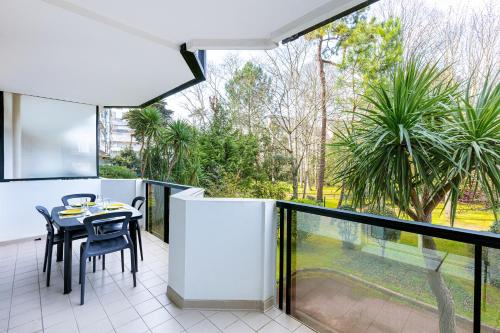 un patio avec une table et des chaises sur un balcon dans l'établissement Les pieds dans le sable de la Plage Benoît - T2, à La Baule