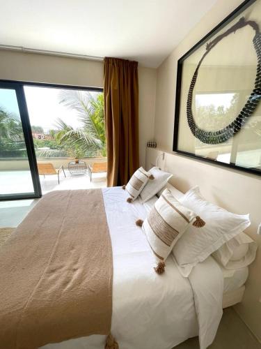 a bedroom with a large bed with a large window at Villa YEMAYA - Villa d'hôtes in Ngaparou