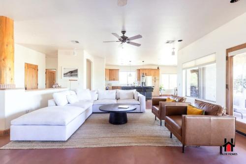 uma sala de estar com um sofá branco e uma mesa em Grand Desert Getaway with Pool and Peloton with Sonos and Office em Rio Verde