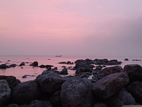 a group of rocks in the ocean at sunset at Villa YEMAYA - Villa d'hôtes in Ngaparou
