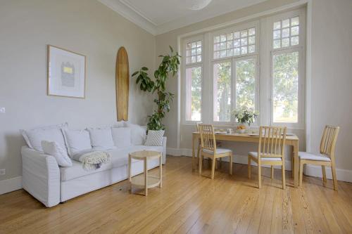 un salon avec un canapé blanc et une table dans l'établissement Appartement Magnolia 4 étoiles avec parking - Welkeys, à Biarritz