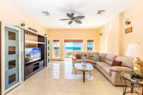 a living room with a couch and a tv at Breathtaking Chalk Sound Private Pool Sunset Villa in Providenciales