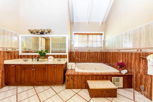ein großes Bad mit einer Badewanne und einem großen Spiegel in der Unterkunft Breathtaking Chalk Sound Private Pool Sunset Villa in Providenciales