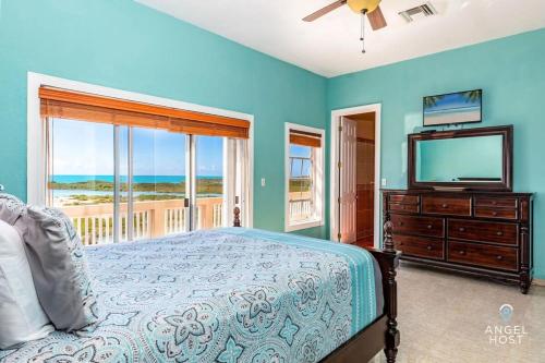 - une chambre avec un lit, une télévision et un balcon dans l'établissement Breathtaking Chalk Sound Private Pool Sunset Villa, à Providenciales