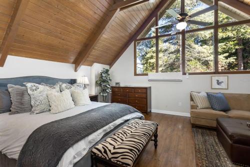 a bedroom with a bed and a couch and windows at Snowflower Cabin Modern Luxe, 2 Level, 1500 sqft, AC, View, Dogs, Walk to Village in Lake Arrowhead