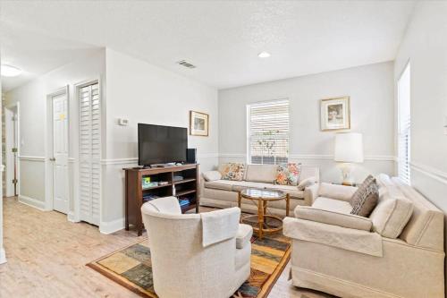uma sala de estar com dois sofás e uma televisão em Cute Downtown Cottage with Large Yard and BBQ plus Smart TVs em St. Augustine