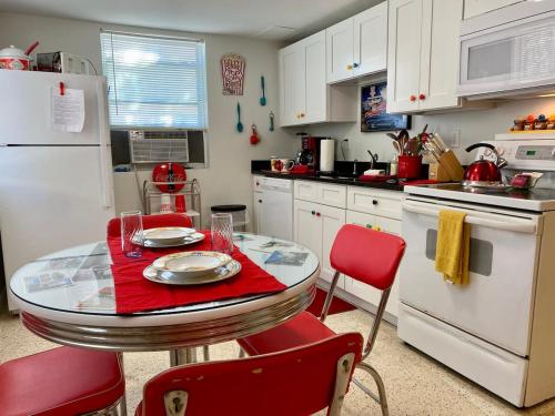 a kitchen with a table with red chairs and white appliances at Funky Downtown Pad Pets OK Near Intercoastal in St. Augustine