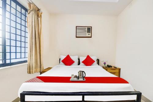 a bedroom with a large bed with red pillows at OYO The Safe Hotels in Cochin