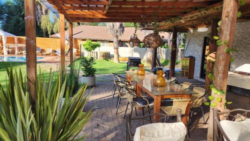 a patio with a table and chairs under a pergola at habitaciones con piscina en tinguiririca san fernando in San Fernando