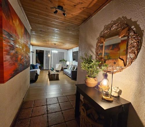 a living room with a table and a mirror at habitaciones con piscina en tinguiririca san fernando in San Fernando