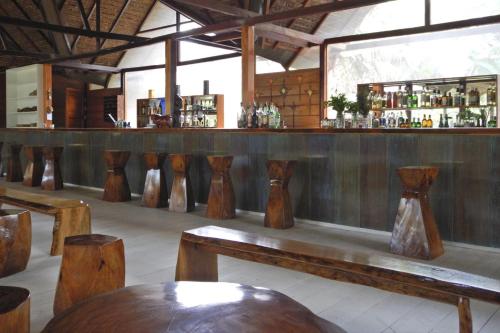 un bar con jarrones de madera alineados contra una pared en Tambopata Ecolodge, en Tambopata