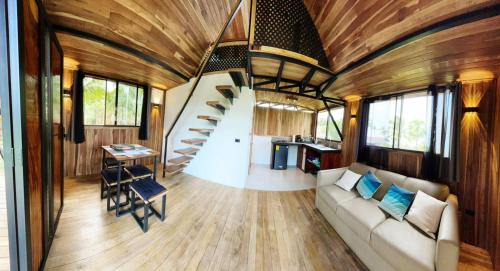 a living room with a staircase in a tiny house at Myra Chalets in Bijagua