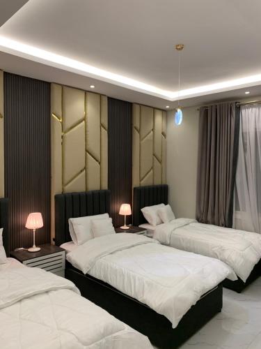 een slaapkamer met 2 bedden en 2 lampen op tafels bij سيلينا هاوس الفندقية in Jeddah