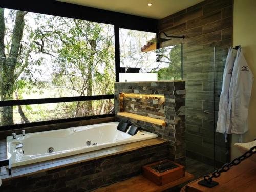 een bad in een badkamer met een groot raam bij Hípico Diamante in Tapalpa
