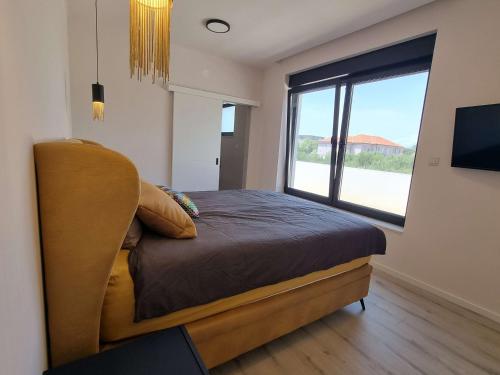 a bedroom with a bed and a large window at Holiday house with a swimming pool Banjol, Rab - 22703 in Rab