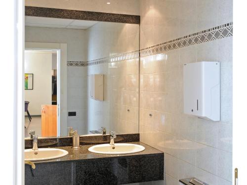 Baño con 2 lavabos y espejo en Tuscia Hotel, en Viterbo
