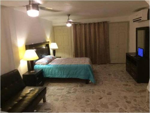- une chambre avec un lit, un canapé et une télévision dans l'établissement NEW Marina Vallarta Loft Pool BBQ Beach 5 mins, à Puerto Vallarta
