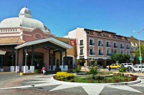 a building in a city with a parking lot at NEW Plaza Marina Vallarta Loft Pool BBQ Beach 10 min in Puerto Vallarta