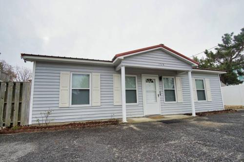 a white house with a fence in front of it at Bungalow Bliss ※ Beach Cottage Blocks From Ocean in Myrtle Beach