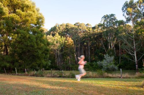 a woman running in the grass in a park at BIG4 Yarra Valley Park Lane Holiday Park in Healesville