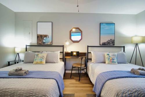 a bedroom with two beds and a desk in it at Bungalow Bliss ※ Beach Cottage Blocks From Ocean in Myrtle Beach