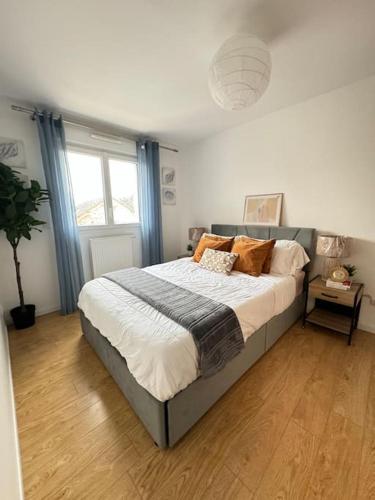 een slaapkamer met een groot bed met oranje kussens bij La villa six_jml in Ris-Orangis