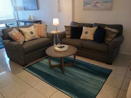 a living room with two couches and a coffee table at Direct ocean front view 1 bedroom working pool in Daytona Beach