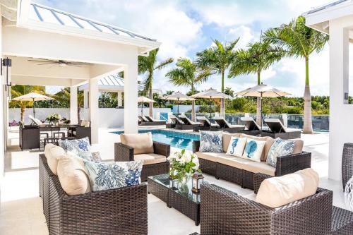 an outdoor patio with wicker furniture and a swimming pool at Caribbean Escape Luxe Waterfront Villa with Pool in Long Bay Hills