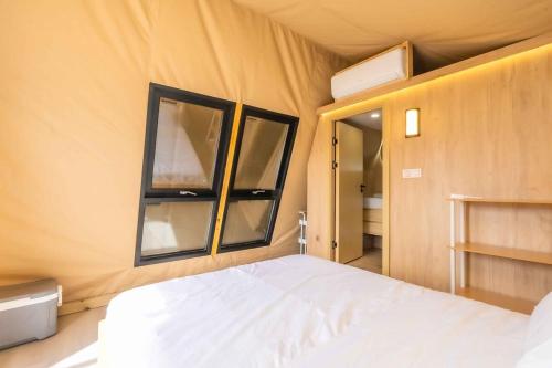 a bedroom with a bed and two windows at Glamping in the Urban in Glendora