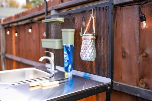 a kitchen counter with a sink and a bottle of water at Glamping in the Urban in Glendora