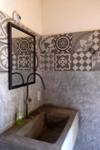 a sink in a bathroom with a mirror and tiles at Casa Bonita in Puerto Escondido
