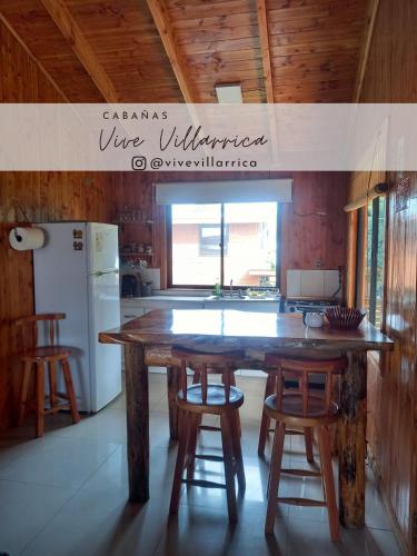een keuken met een grote houten tafel en stoelen bij Cabaña 1 Vive Villarrica in Villarrica