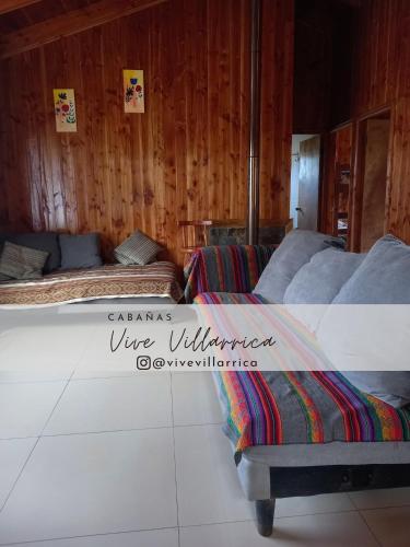 twee bedden in een kamer met houten wanden bij Cabaña 1 Vive Villarrica in Villarrica