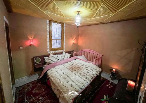 een slaapkamer met een roze bed en een plafond bij Villa Mouloud réservée aux familles in Arrougou