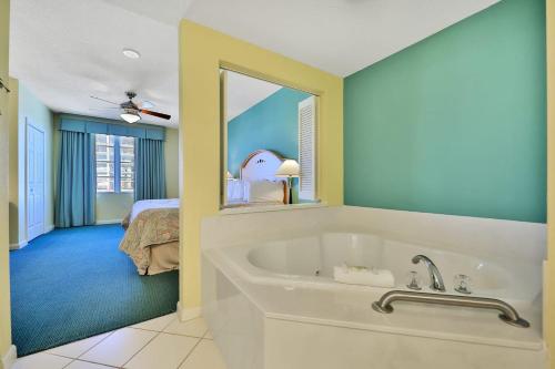 a bathroom with a tub and a bedroom with a bed at Ocean Walk Condominiums in Daytona Beach