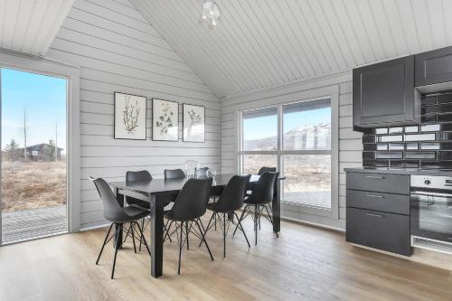 a dining room with a table and black chairs at Spacious 4-Bedroom Home in Southern Iceland in Selfoss