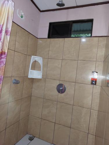 a shower in a bathroom with a tile wall at Chinitas Eco Lodge in Tortuguero