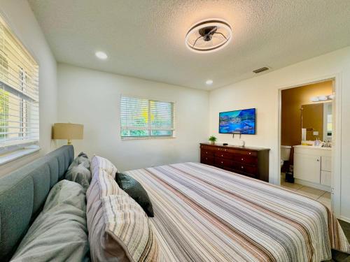 a bedroom with a bed and a dresser and a tv at Seaside Elegance 3 Mi to FM Beach Paradise Sleep 6 in Fort Myers Beach