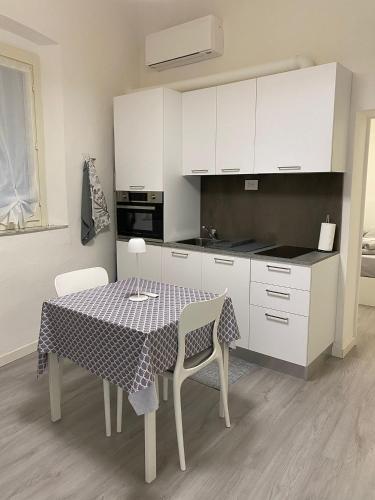 a kitchen with a table and white cabinets at II Sogno nel Vicolo in Pisa